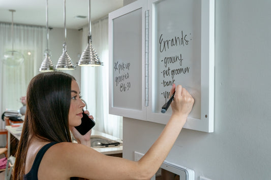 a woman is writing on a white board