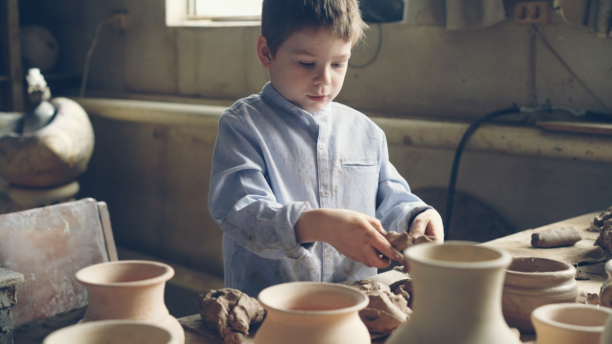 A young boy crafts pottery.