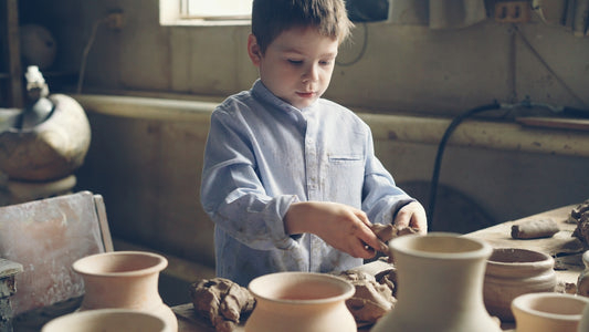 A young boy crafts pottery.
