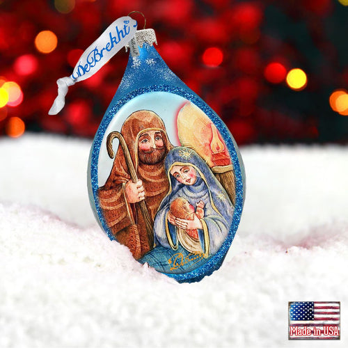 Decorative Christmas ornament with a nativity scene design, featuring a blurred festive background.
