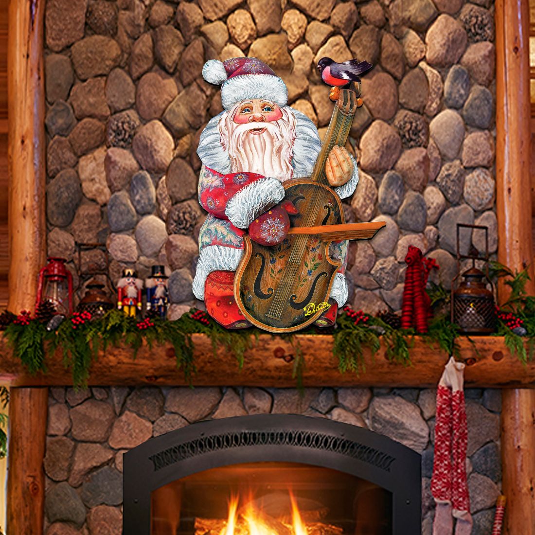 Decorative Santa Claus figure on a stone fireplace with a lit fire.